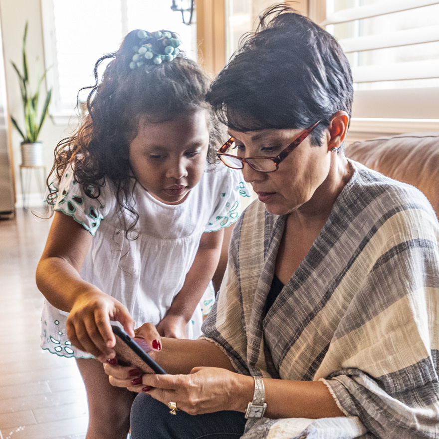 Grandma and granddaughter using mobile phone