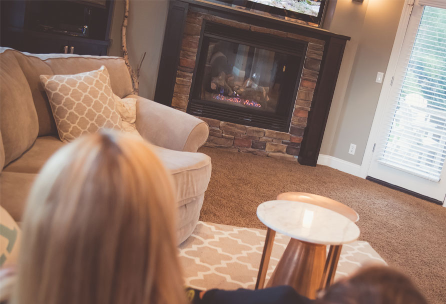 woman sitting in front of natural gas fireplace