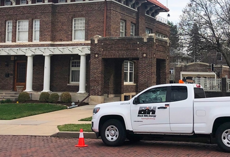 Black Hills Energy pickup parked in front of a house on a residential street.