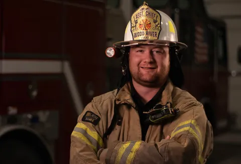 Fireman posing in front of firetruck