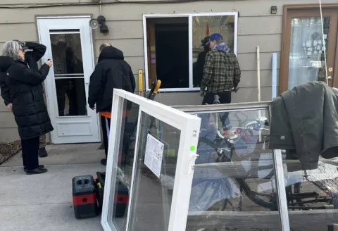 A group of people working at a house replacing windows