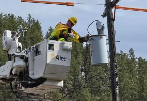 Lineman in a bucket repairing a transformer